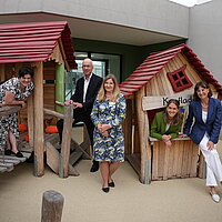 Claudia Rautenberg, Leiterin des Amts für städtische Kindertageseinrichtungen, Sozialbürgermeister Frank Fillbrunn, die stellvertretende Kita-Leiterin Barbara Pfützner, Kita-Leiterin Rebecca Bös und die ehemalige städtische Projektleiterin Andrea Hermesmeier (von links) haben die Kita Schlossberghöfe offiziell eingeweiht. Auf dem Bild stehen Sie vor den neuen Spielgeräten der Kita-Kinder.