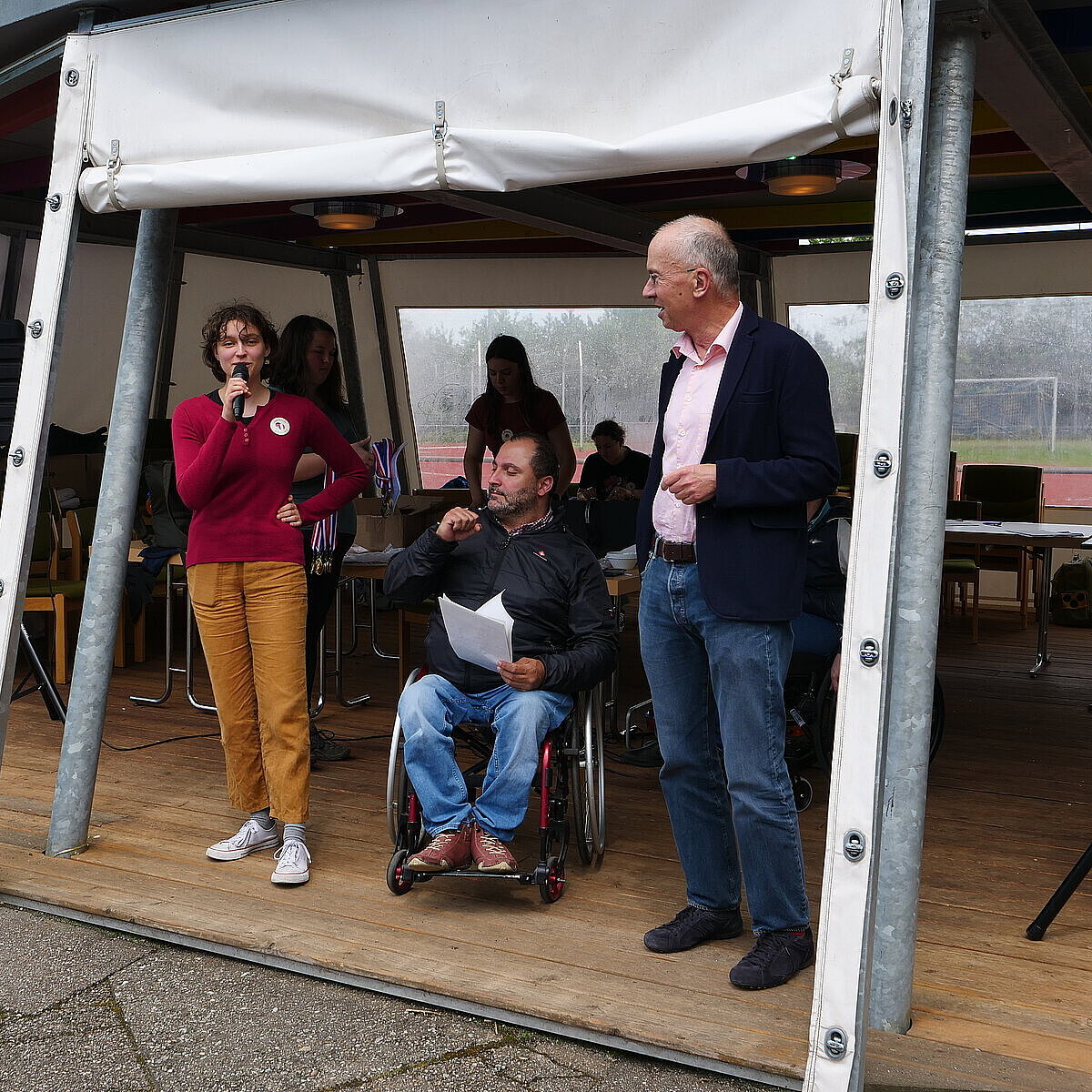 Jeanne Mercier, Inklusionsbeauftragter Mohamed Zakzak und Sozialbürgermeister Frank Fillbrunn vor einem Zelt mit Mikros in der Hand - copyright:Stadt Pforzheim