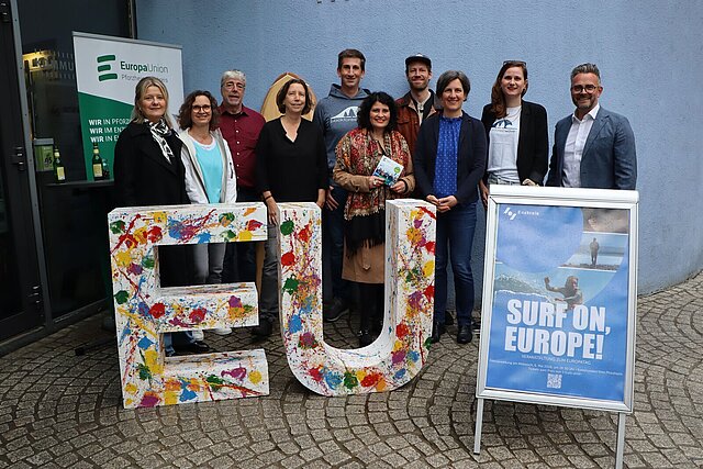 Viele Personen stehen aufgereiht hinter großen Buchstaben, die das Wort EU bilden