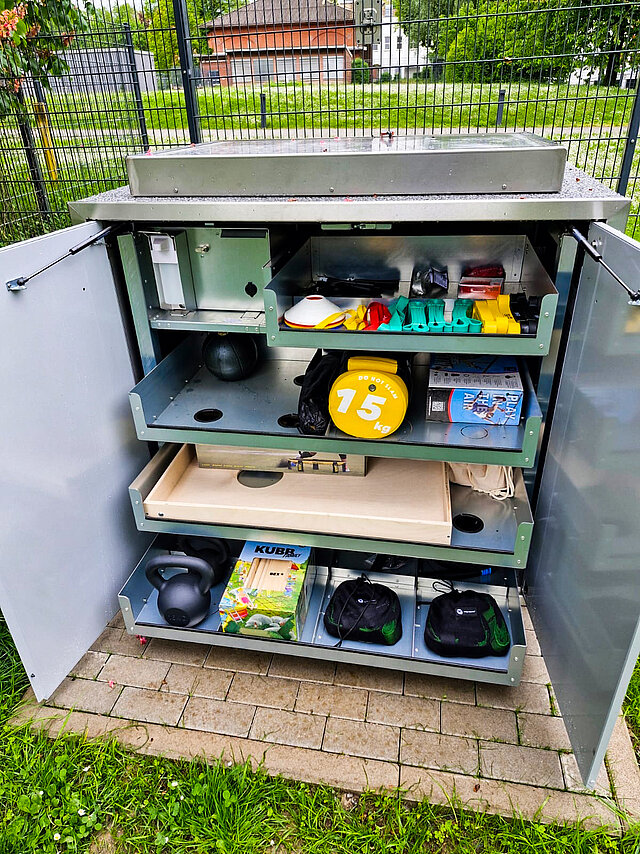 Sportbox mit Sportgeräten, wie Hanteln und Seile