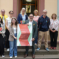 Elf Personen, die sich am Programm des Brötzinger Kulturfestes beteiligen, stehen vor dem Stadtmuseum Brötzingen. In der Mitte steht Kulturbürgermeister Tobias Volle und hält das Plakat zum Brötzinger Kulturfest vom 25. bis 27. September 2026, eine Frau links mehrere Programmflyer. 