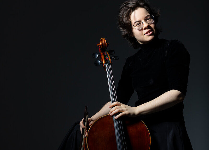 zeigt Maria Zaitseva mit einem Cello vor schwarzem Hintergrund - copyright: Maria Zaitseva - Ersteller: Volkov Vladimir