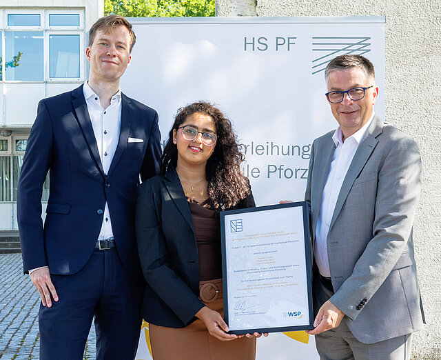 Maximilian Motz, Yusrea Valiyakath und WSP-Direktor Oliver Reitz präsentieren bei der Förderpreisverleihung der Hochschule Pforzheim die Auszeichnung für die Studie zur Busanbindung.