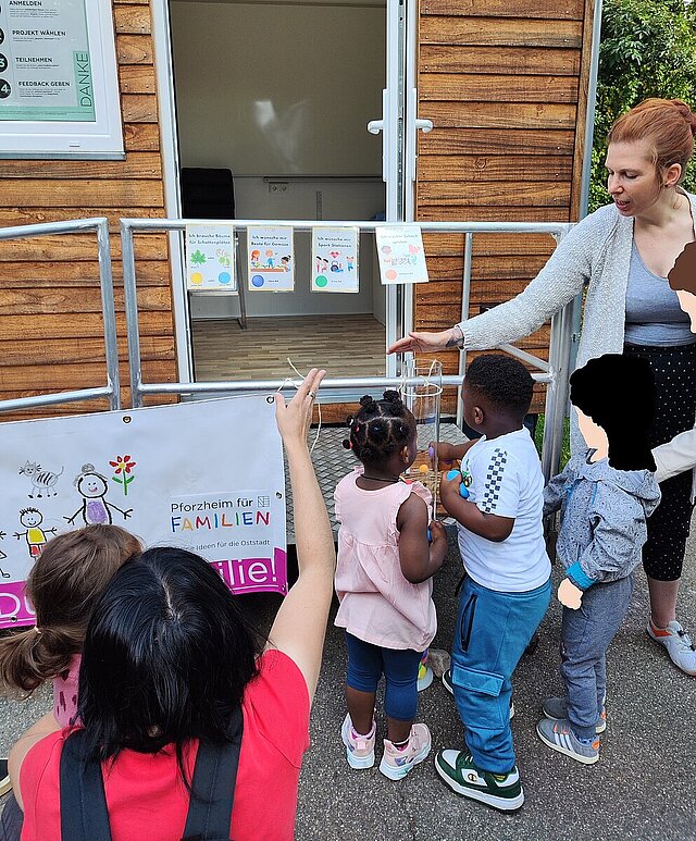 Kinder und Eltern werfen Bälle in eine Plexiglasröhre und nehmen so an der Abstimmung teil - copyright:Juliane Wagner