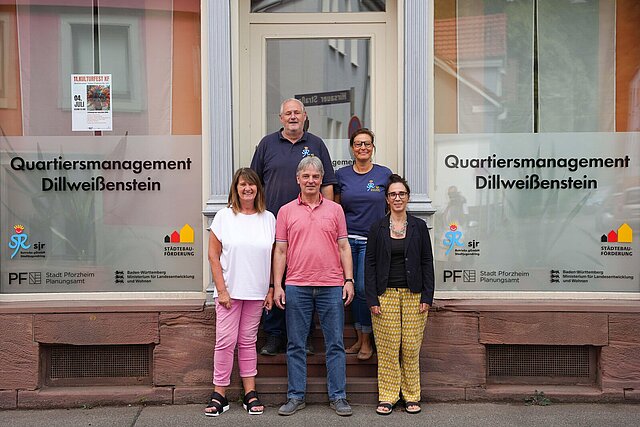 Fünf Personen stehen vor einem Gebäude, mit der Aufschrift "Quartiersmanagement Dillweißenstein"