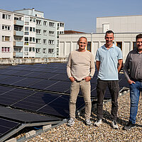 Rainer Störzenecker, Sachgebietsleitung Technische Gebäudeausrüstung im Gebäudemanagement, Stephan Bürkle, Feuerwehr Pforzheim und Jan Kühner, Projektleiter der technischen Gebäudeausrüstung stehen auf dem Dach der Hauptfeuerwache in Pforzheim vor der neu errichteten Photovoltaikanlage.