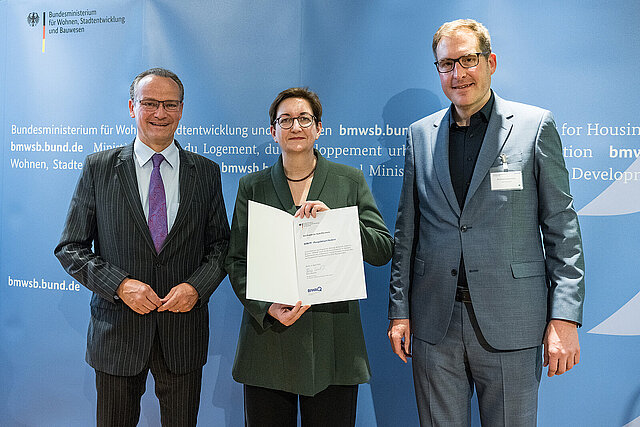 Die Bundesministerin für Wohnen, Stadtentwicklung und Bauwesen, Klara Geywitz, überreichte die Förderurkunde an den Pforzheimer Bundestagsabgeordneten Gunther Krichbaum (links) und Andreas Hennrichs von der kommunalen Beschäftigungsförderung der Stadt. 