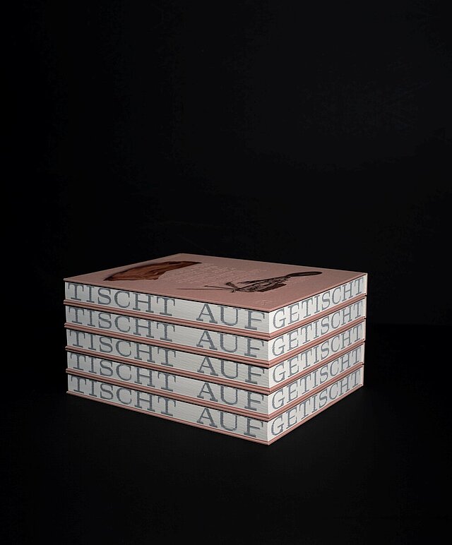 Mehrere aufeinandergestapelte Bücher vor einem schwarzen Hintergrund