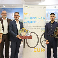 Farbfoto: v.l.n.r.: Freuen sich über die Ausgabe des 250. Begrüßungsgutschein für Studierende: Miriam Fieser, Prof. Dr. Frank Niemann, Oberbürgermeister Peter Boch, Student Rafat Khaled mit Partnerin Diana Kostrova und Sohn Amir sowie Markus Epple.