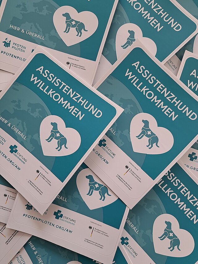 Viele Aufkleber Assistenzhunde Willkommen liegen übereinander verstreut. - copyright:Stadt Pforzheim
