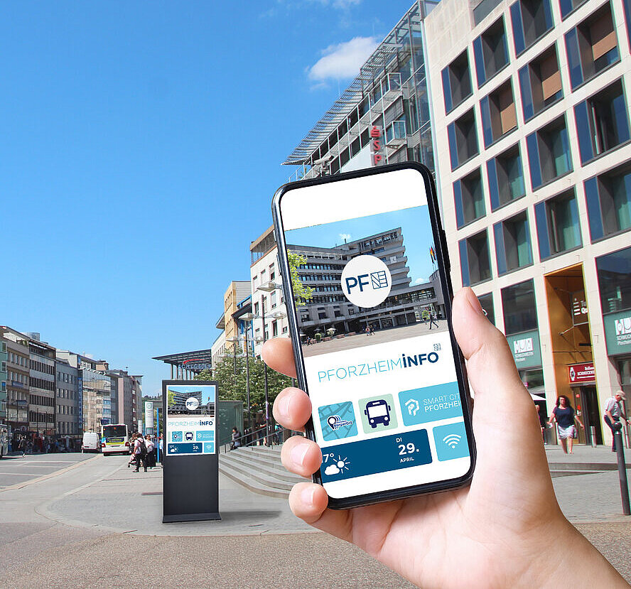 Das Bild zeigt eine digitale Stele und eine Hand mit einem Handy, auf dem die geplante Stadt-App zu sehen ist. - copyright:Stadt Pforzheim