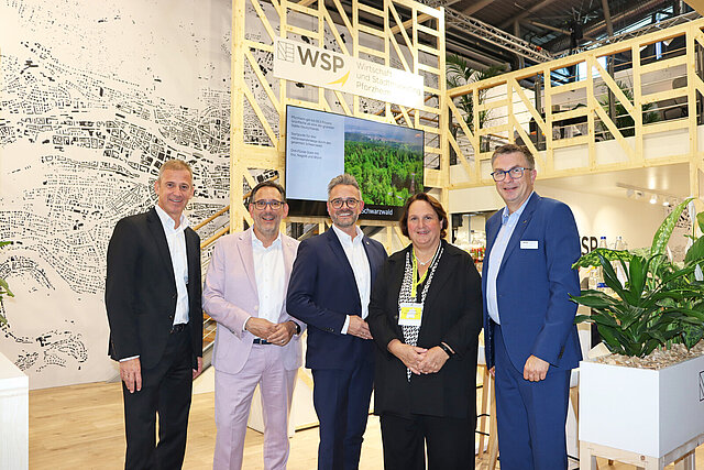 Auf dem Bild zu sehen sind 5 Personen. Diese 5 Personen sind  Ministerialdirektor im Ministerium für Landesentwicklung und Wohnen Baden-Württemberg Daniel Hager-Mann, Bürgermeister Tobias Volle, Oberbürgermeister Peter Boch, Ministerin für Landesentwicklung und Wohnen Baden-Württemberg Frau Theresa Schopper und WSP-Direktor Oliver Reitz. Sie stehen vor dem Messestand auf der EXPO-Real. 