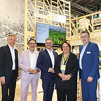 Auf dem Bild zu sehen sind 5 Personen. Diese 5 Personen sind  Ministerialdirektor im Ministerium für Landesentwicklung und Wohnen Baden-Württemberg Daniel Hager-Mann, Bürgermeister Tobias Volle, Oberbürgermeister Peter Boch, Ministerin für Landesentwicklung und Wohnen Baden-Württemberg Frau Theresa Schopper und WSP-Direktor Oliver Reitz. Sie stehen vor dem Messestand auf der EXPO-Real. 