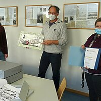 Karikaturist Gerald Manz, Sammlungsarchivarin Andrea Binz-Rudek (r.) und Archivleiterin Klara Deecke mit dem neuen Archivbestand