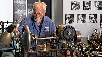 Historische Kettenmaschine im Technischen Museum Bild: Mann im Technischen Museum an historischen Kettenmaschinen