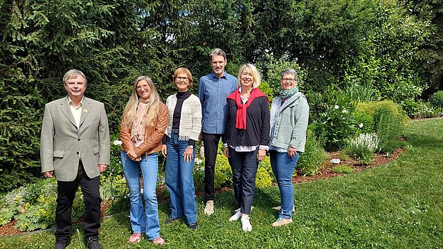 Eine Gruppe von Personen stehen in einem Garten
