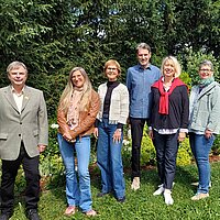 Eine Gruppe von Personen stehen in einem Garten
