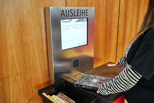 Foto: Eine Person am Ausleih-Terminal in der Stadtbibliothek. - copyright:Daniel Foltin, Ines Neumann