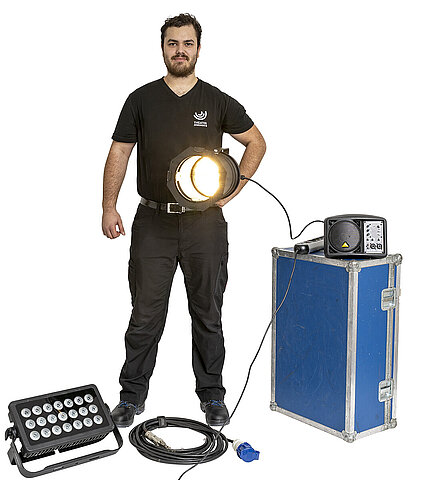 Symbolbild: Azubi Fachkraft für Veranstaltungstechnik mit typischem Beleuchtungsequipment.
