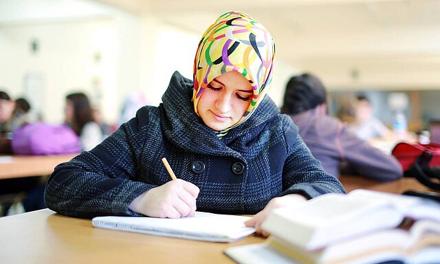Muslim girl studying in library