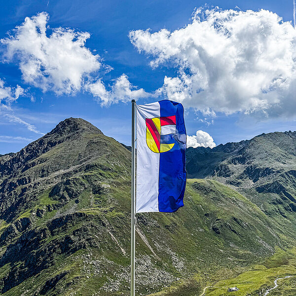 Die Pforzheimer Fahne weht vor dem Tiroler Alpenpanorama. - Copyright: Stadt Pforzheim