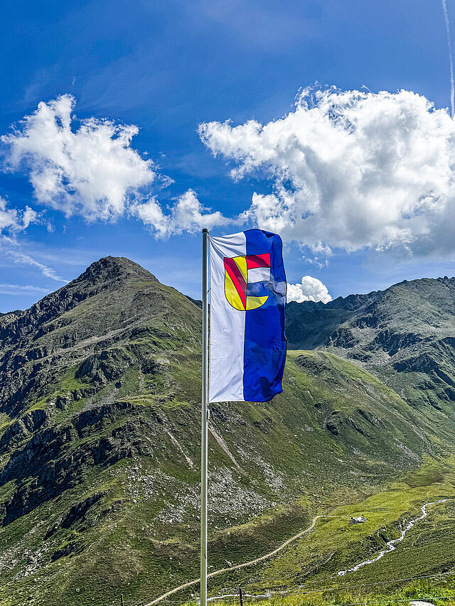 Die Pforzheimer Fahne weht vor dem Tiroler Alpenpanorama.