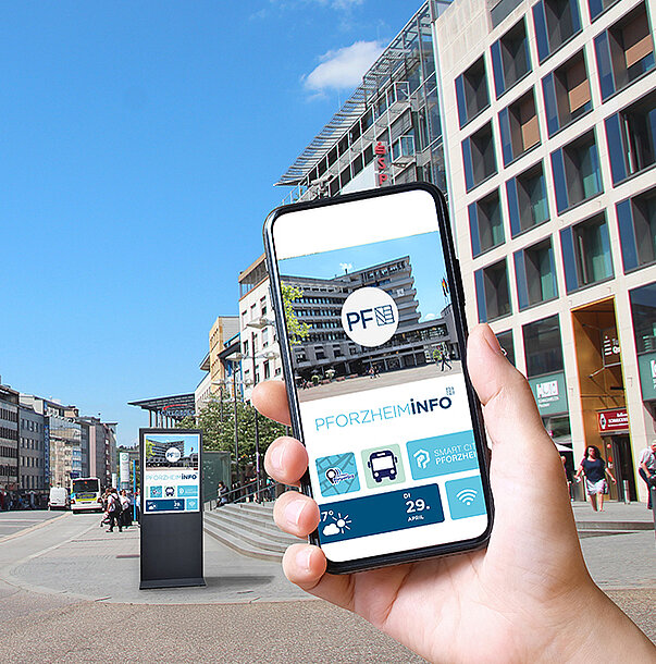 Das Bild zeigt eine digitale Stele und eine Hand mit einem Handy, auf dem die geplante Stadt-App zu sehen ist.  - copyright:Stadt Pforzheim