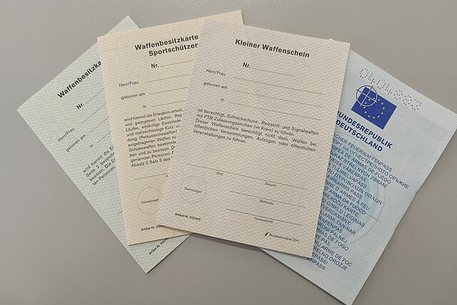 Mehrere waffenrechtliche Anträge liegen gefächert auf einem Tisch