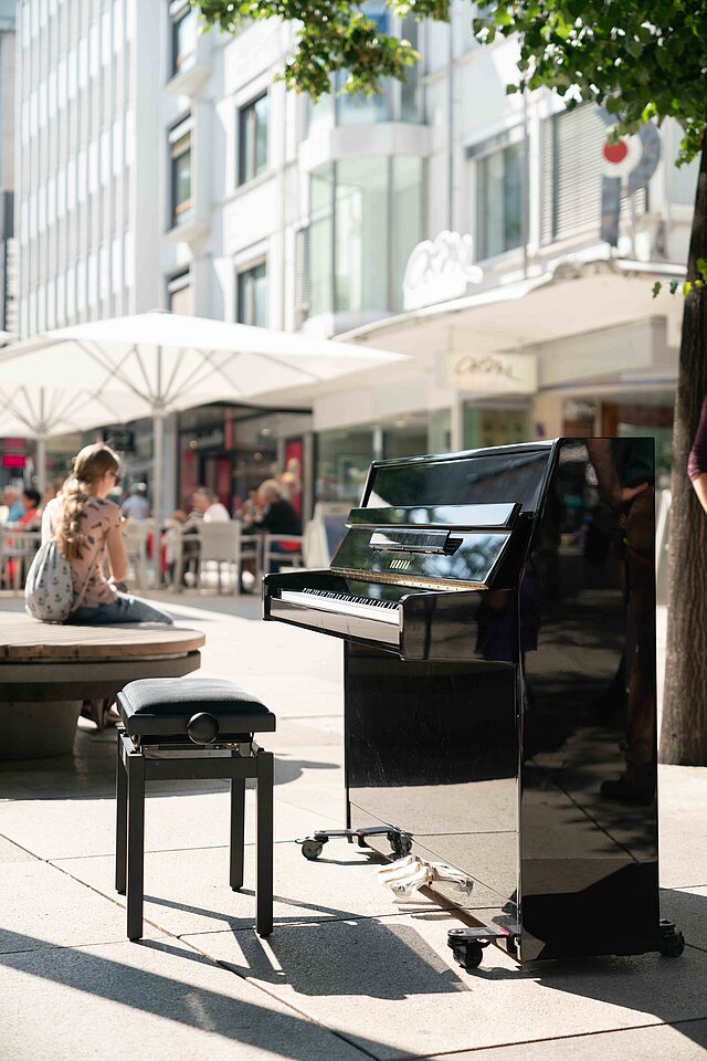 Farbfoto: Schwarzes Klavier steht in der Innenstadt