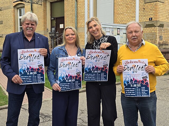 Vier Personen halten jeweils ein Plakat in die Höhe.