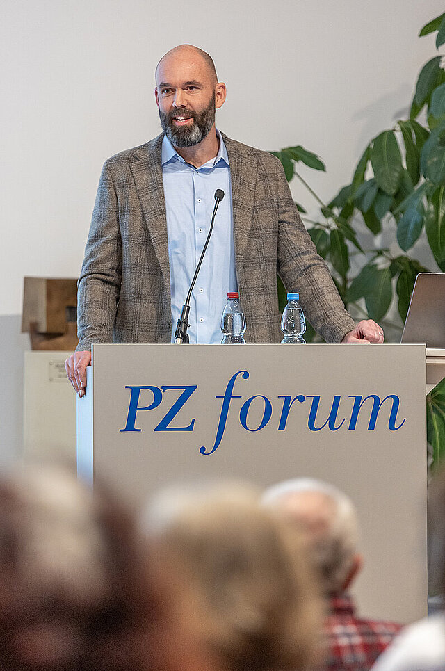 Sozialpädagoge Clemens Beisel spricht in ein Mikrofon 