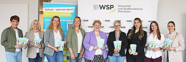 Die Beteiligten Menschen stehen in Reihe vor einem Plakat