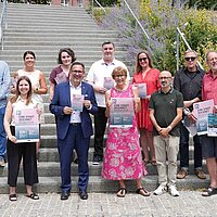 Viele Personen stehen auf einer Treppe und halten Plakate in den Händen.