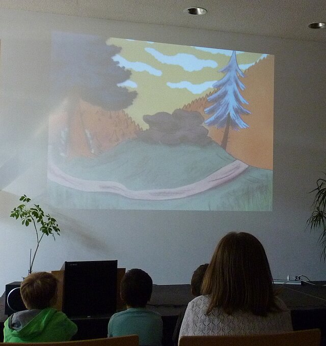 Fotografie von Kindern die vor einer Leinwand sitzen. - copyright:Stadtbibliothek