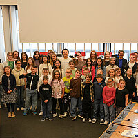 Eine Gruppe von Kindern und Jugendlichen im Sitzungssaal im Neuen Rathaus Pforzheim.