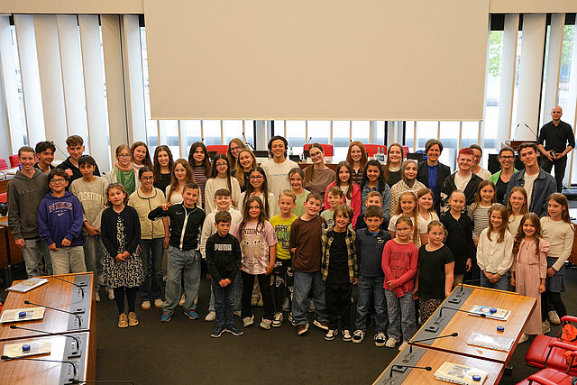 Eine Gruppe von Kindern und Jugendlichen im Sitzungssaal im Neuen Rathaus Pforzheim.