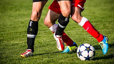 Männerbeine spielen Fußball