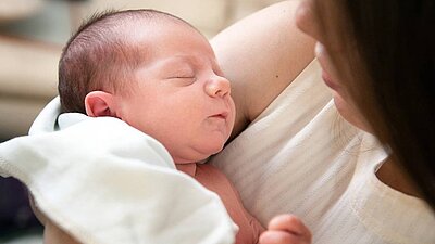 Neugeborenes im Arm der  Mutter