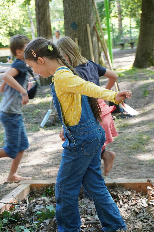 Kinder laufen auf dem Barfußpark im Wildpark