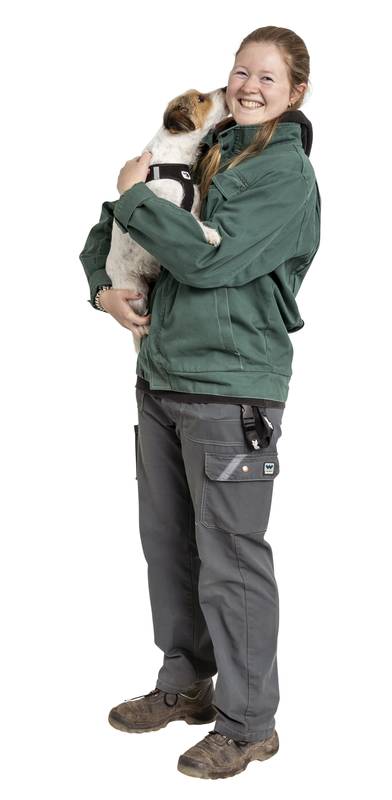 Tierpflegerin in der Ausbildung mit Hund auf dem Arm