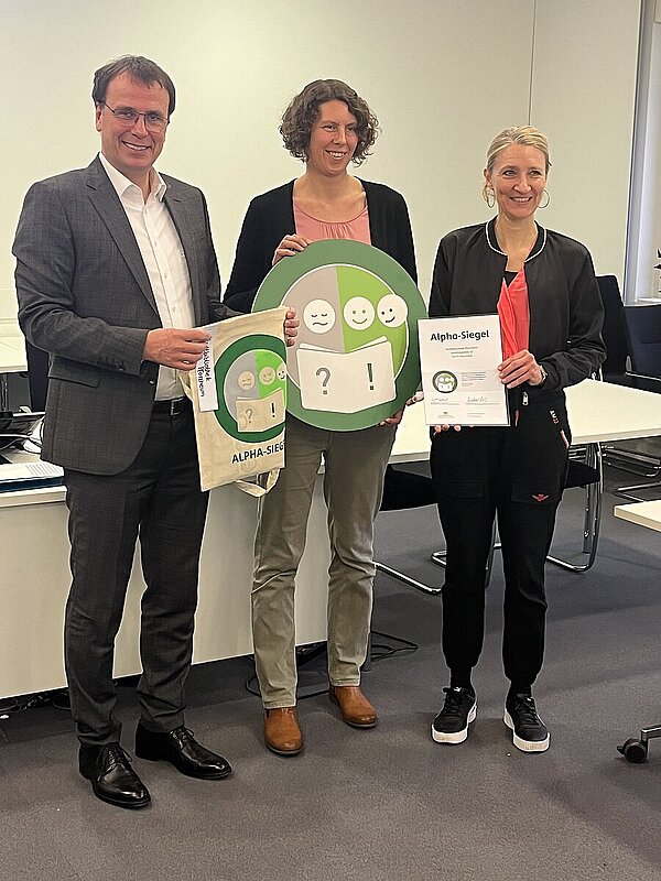 v.l.: Staatssekretär Volker Schebesta, stellvertr. Amtsleiterin Marion Hekmann, Leiterin Öffentlichkeitsarbeit Ruth Jaeckle bei der Verleihung des Alpha-Siegels v.l.: Staatssekretär Volker Schebesta, stellvertr. Amtsleiterin Marion Hekmann, Leiterin Öffentlichkeitsarbeit Ruth Jaeckle bei der Verleihung des Alpha-Siegels